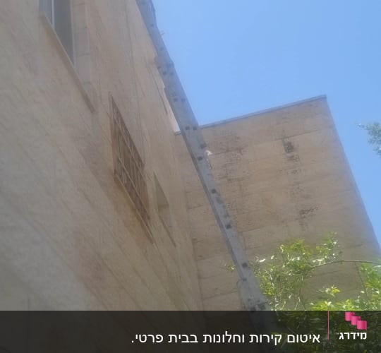 סולם מונח על קיר בניין לאיטום